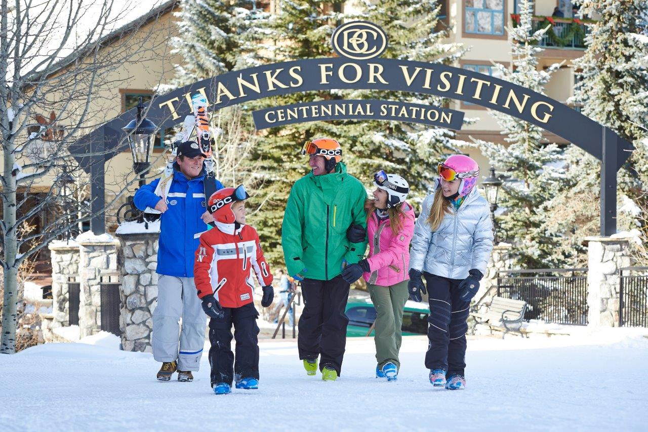 Family in brightly colored ski gear leaves Centennial Station at Beaver Creek Ski Resort